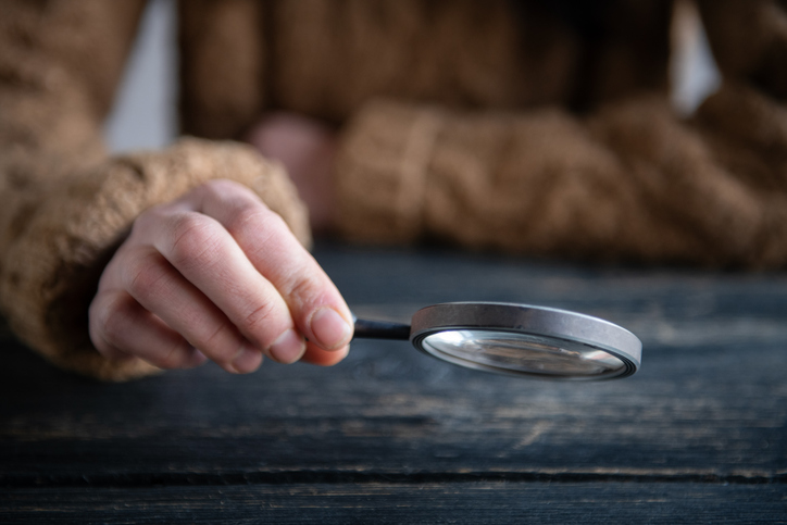 Hand with magnifying lens