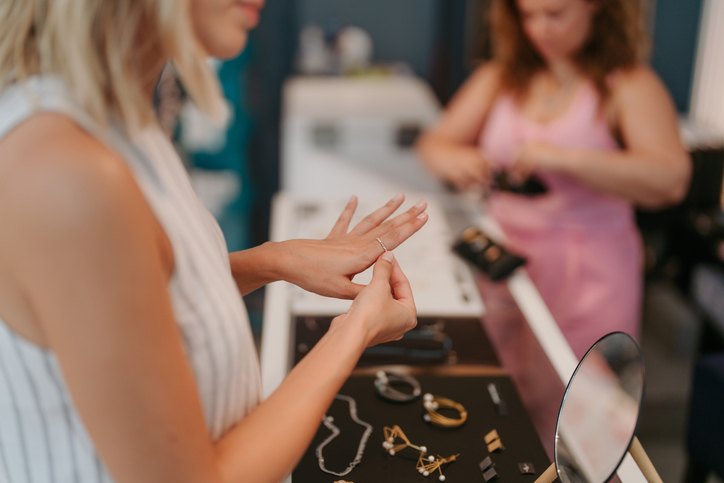 Photo of a young woman choosing a ring at the souvenir shop